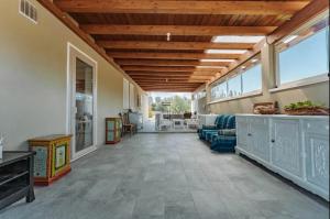 een grote woonkamer met een blauwe bank en ramen bij Tenuta Naturale in Villa San Pietro