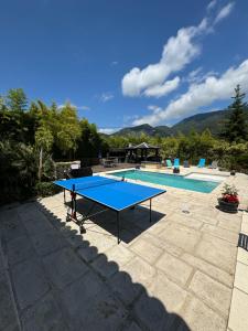 a blue ping pong table in front of a swimming pool at Les Bambous B&B in Levens