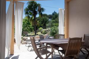 a table and chairs on a patio with a view of a garden at Villa il Poderino in Marina di Campo