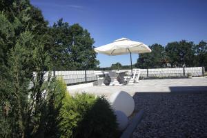 Un patio con sombrilla y sillas y una mesa. en Apartment - CASA Adrianovo, en Ljubuški