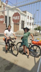 two people standing with their bikes in front of a fence at Casita Libertad Chorrillos in Lima