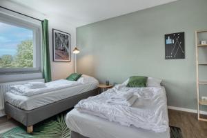 two beds in a room with a window at Stillvolle Wohnung bei Köln / Bonn Flughafen in Lohmar +30 photos