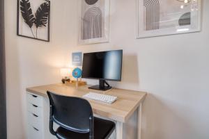 a desk with a computer monitor and a keyboard at Stillvolle Wohnung bei Köln / Bonn Flughafen in Lohmar