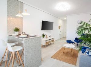 a living room with a bar and chairs and a tv at Thader I Apartment with views in Rojales