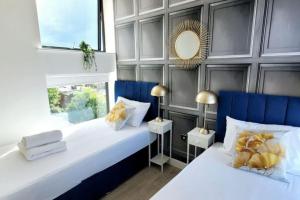 two beds in a room with white and blue at City view luxury by BSE Homes in Chelmsford