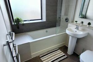 a bathroom with a sink and a bath tub and a toilet at City view luxury by BSE Homes in Chelmsford