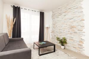 een woonkamer met een bank en een bakstenen muur bij New Apartment in Vrnjačka Banja