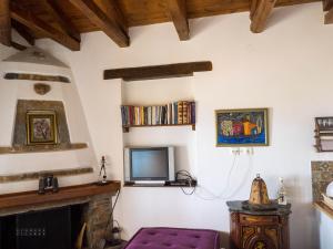a living room with a tv and a fireplace at Kiwi stonehouse in Chorefto