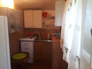 a small kitchen with a sink and a stove at Domek nad jeziorem in Wąchabno