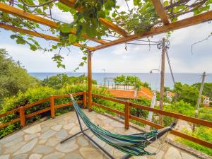 a hammock on a balcony with a view of the ocean at Kiwi stonehouse in Chorefto