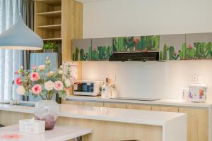 a kitchen with a counter with a microwave and flowers at Cactus-si! Villa - Managed by LyGia in Long Hai