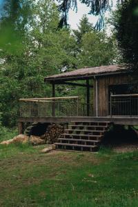 ein Holzgebäude mit Terrasse und Treppe in der Unterkunft BANDIAT Le Domaine in Fargeas
