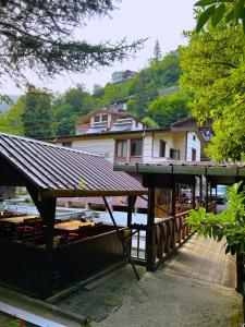 a wooden deck with a building and a house at Isikli Kale Hotel in Çaykara