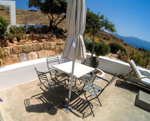 a table and chairs with an umbrella on a patio at Domatia me Thea in Elafonisos
