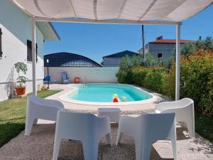 a pool with white chairs and a table and a swimming pool at Alba Marina Rooms in Tollo
