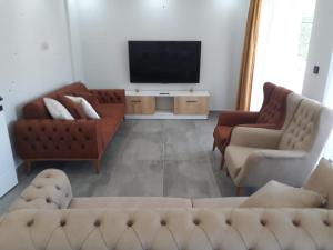 a living room with two couches and a flat screen tv at Villa Vineyard in Fethiye