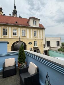 einen Balkon mit 2 Stühlen und ein Gebäude in der Unterkunft Blue House Citadel Elite Sighisoara in Sighişoara