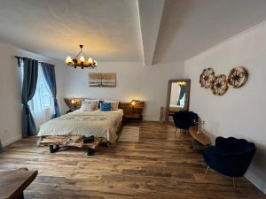 ein Schlafzimmer mit einem Bett, einem Spiegel und einer Gitarre in der Unterkunft Blue House Citadel Elite Sighisoara in Sighişoara