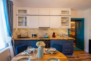 eine Küche mit blauen Schränken und einem Holztisch in der Unterkunft Blue House Citadel Elite Sighisoara in Sighişoara