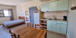 a kitchen with a table and a bed in a room at Domatia me Thea in Elafonisos
