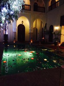 une piscine d'eau éclairée dans un bâtiment dans l'établissement Riad Shama Suites & Spa, à Marrakech