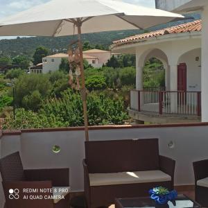 a teddy bear hanging from an umbrella on a balcony at HAIKU HOME in Cala Gonone