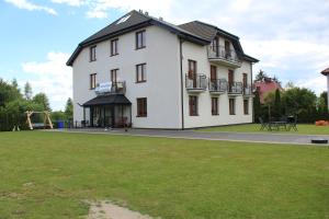 a large white building with a yard in front of it at Albatros in Gąski