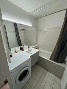 a bathroom with a sink and a washing machine at Studio montagne in Villarembert