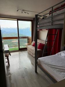a bedroom with two bunk beds and a balcony at Studio montagne in Villarembert