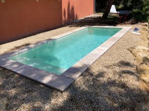 a small swimming pool in a gravel yard at La villa Rosa in Bédoin