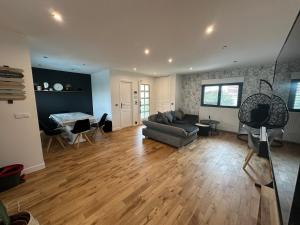a living room with a couch and a table at Charmante maison au Nord de Paris piscine chauffée in Argenteuil