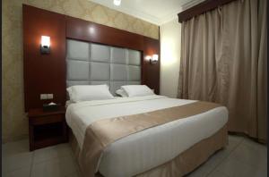 ein Schlafzimmer mit einem großen Bett mit einem hölzernen Kopfteil in der Unterkunft سيزن للوحدات السكنية in Dschidda + 15 Fotos