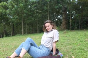 a woman sitting on the grass in a field at Kilimani gardens hostel in Arusha