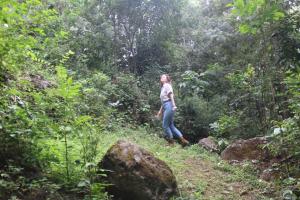 a woman walking on a trail in the jungle at Kilimani gardens hostel in Arusha