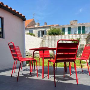 a group of red chairs and a red table at Elégante maison familiale au cœur des remparts de la citadelle in Le Château-dʼOléron