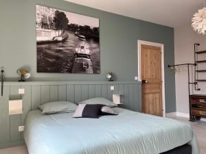 a bedroom with a bed with a picture on the wall at Elégante maison familiale au cœur des remparts de la citadelle in Le Château-dʼOléron