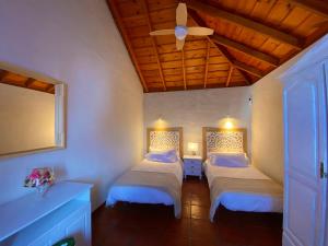 een slaapkamer met twee bedden en een plafondventilator bij Casa El Morro in Los Llanos de Aridane