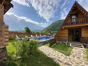 a log cabin with a swimming pool and a house at Eco House Borjomi in Borjomi