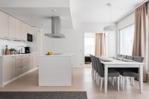 a kitchen and dining room with a white table and chairs at Borg Katarina - Riverside View in Pori