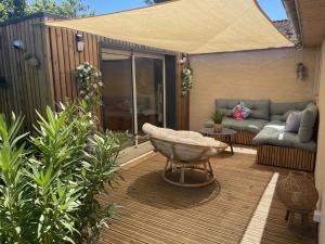 a patio with a couch and a bowl on a deck at Pavillon T2 climatisé in Villefranche-de-Lauragais