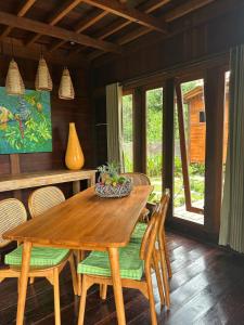 Un comedor con mesa y sillas de madera. en Uma Sepi Villa, en Sukawati
