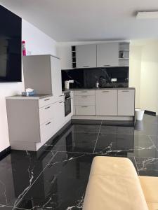 cocina con armarios blancos y suelo de mármol negro en House Cologne Hansaring, en Colonia