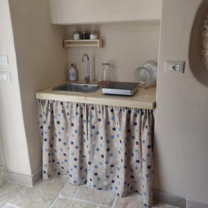 a kitchen counter with a sink in a room at Trullo del Sol in Ceglie Messapica +15 photos