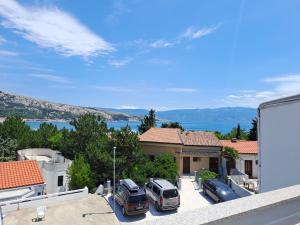 una vista dal balcone di una casa con auto parcheggiate di Apartment Zarok 2 a Baška