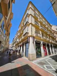 budynek na ulicy z ludźmi idącymi przed nim w obiekcie Málaga centro bonito apartamento w Maladze