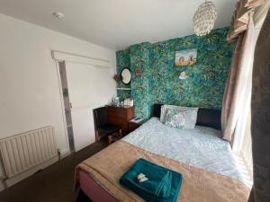 a bedroom with a bed and a green wall at The Northdale Hotel Ltd in Skegness