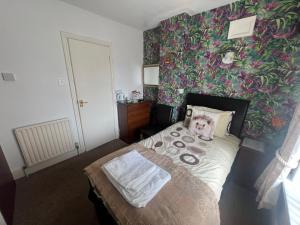 a bedroom with a bed with a floral wallpaper at The Northdale Hotel Ltd in Skegness