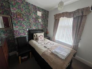 a bedroom with a small bed with a teddy bear on it at The Northdale Hotel Ltd in Skegness