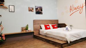 a bedroom with a bed with red pillows on it at Winggarden Murals House by JE Boutique Guesthouse in Ipoh
