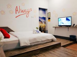 a bedroom with a bed and a tv on a wall at Winggarden Murals House by JE Boutique Guesthouse in Ipoh